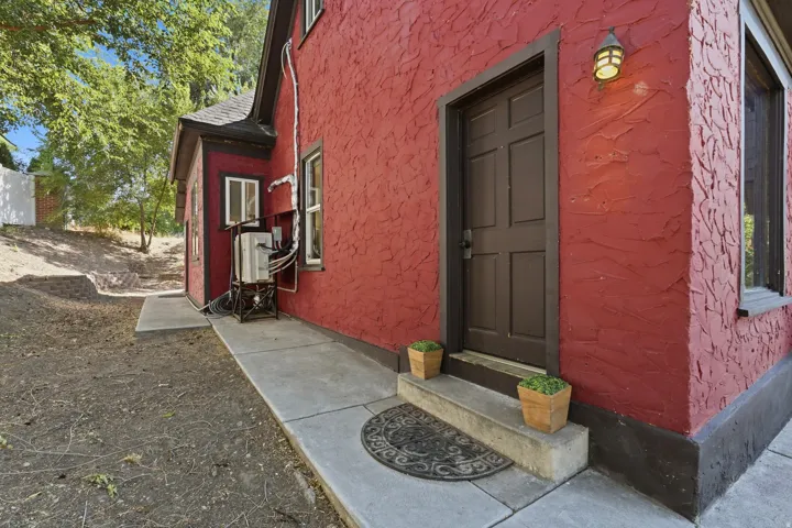 Red textured exterior with dark trim and a paneled entry door