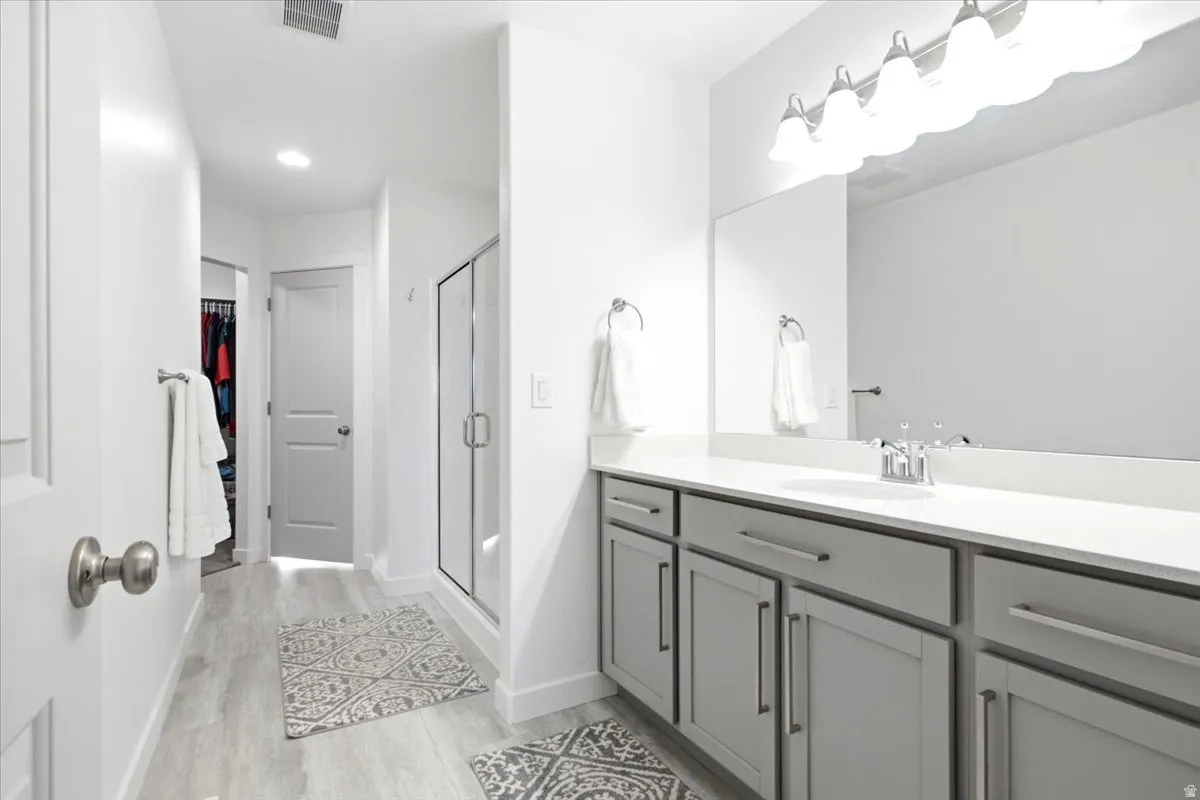 Floating vanity with ample storage, large mirror, and contemporary light fixture