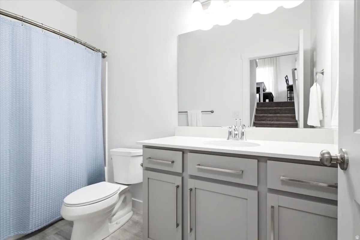 Bathroom featuring a light gray vanity with a white countertop, chrome hardware, and a framed mirror