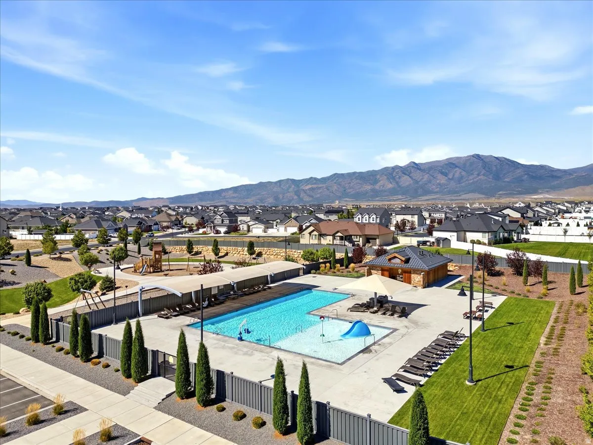Community swimming pool with a water slide, shaded lounge areas, and adjacent playground
