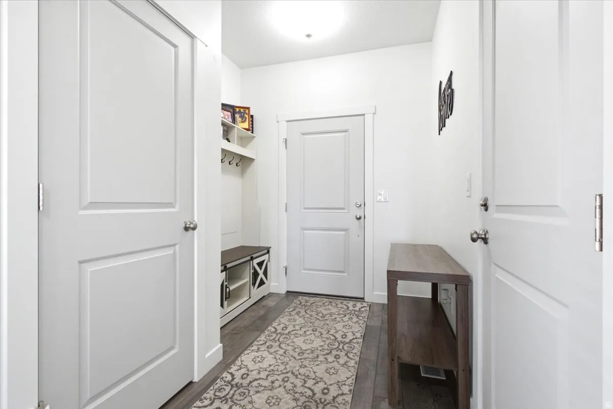 Mudroom entry with wood-finish flooring, built-in shelving, and a bench with integrated storage