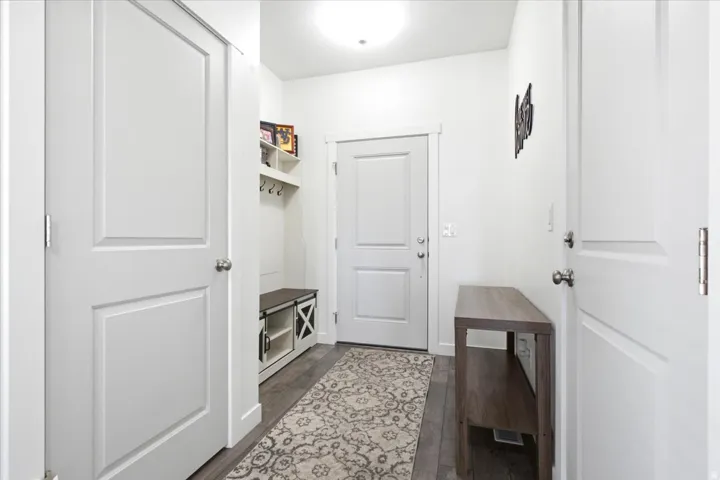 Mudroom entry with wood-finish flooring, built-in shelving, and a bench with integrated storage