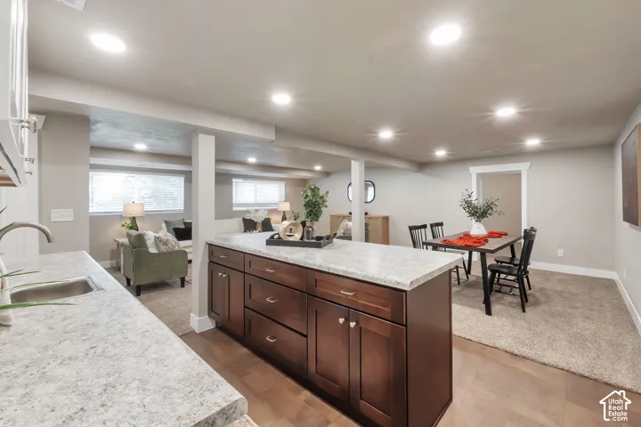 Spacious living area with recessed lighting, wood-finish flooring, and light-toned carpeting