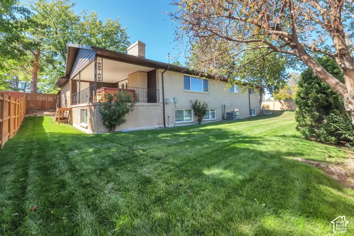 Expansive lawn with a wooden privacy fence and mature trees