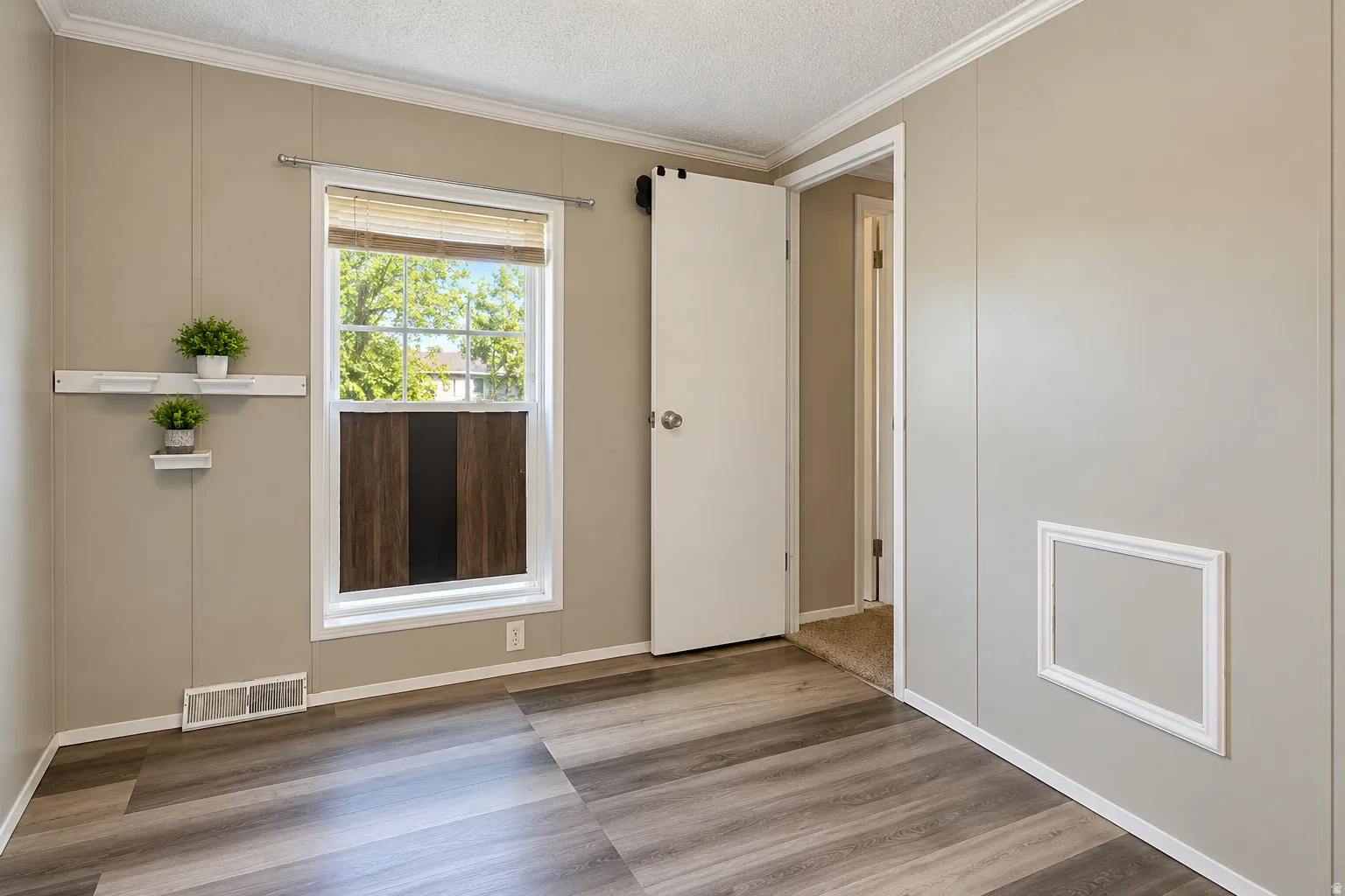 Wood-finish plank flooring, neutral wall paneling, and a white trim package
