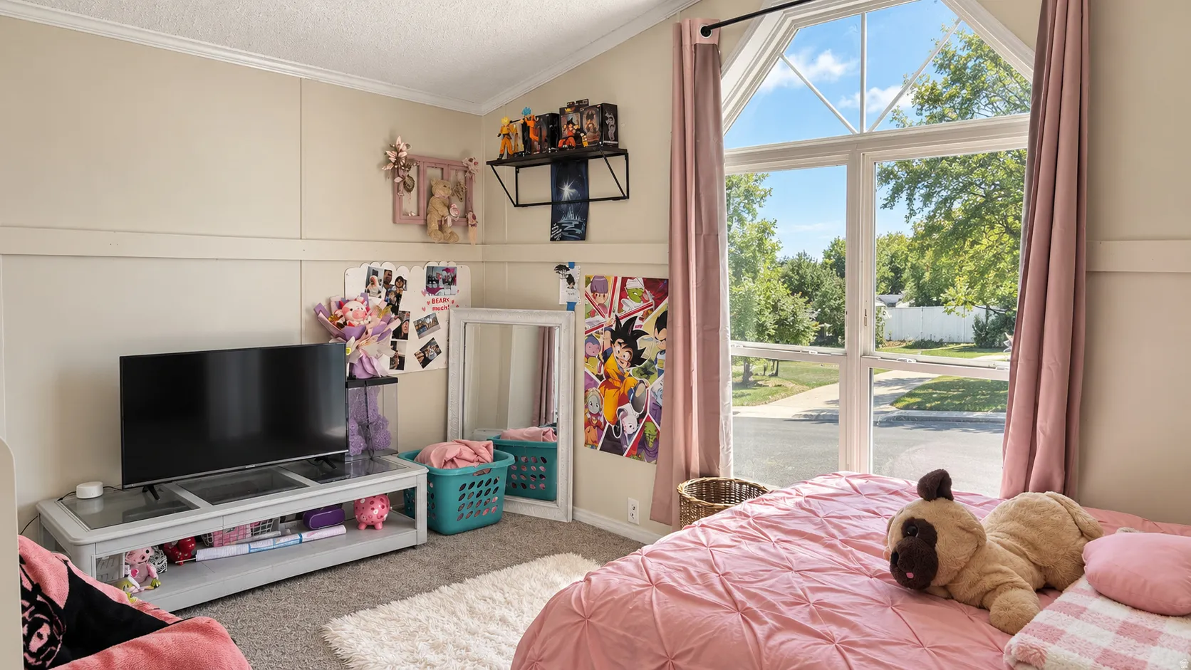 Vaulted ceiling with a large window, board and batten wall detailing, and carpet flooring
