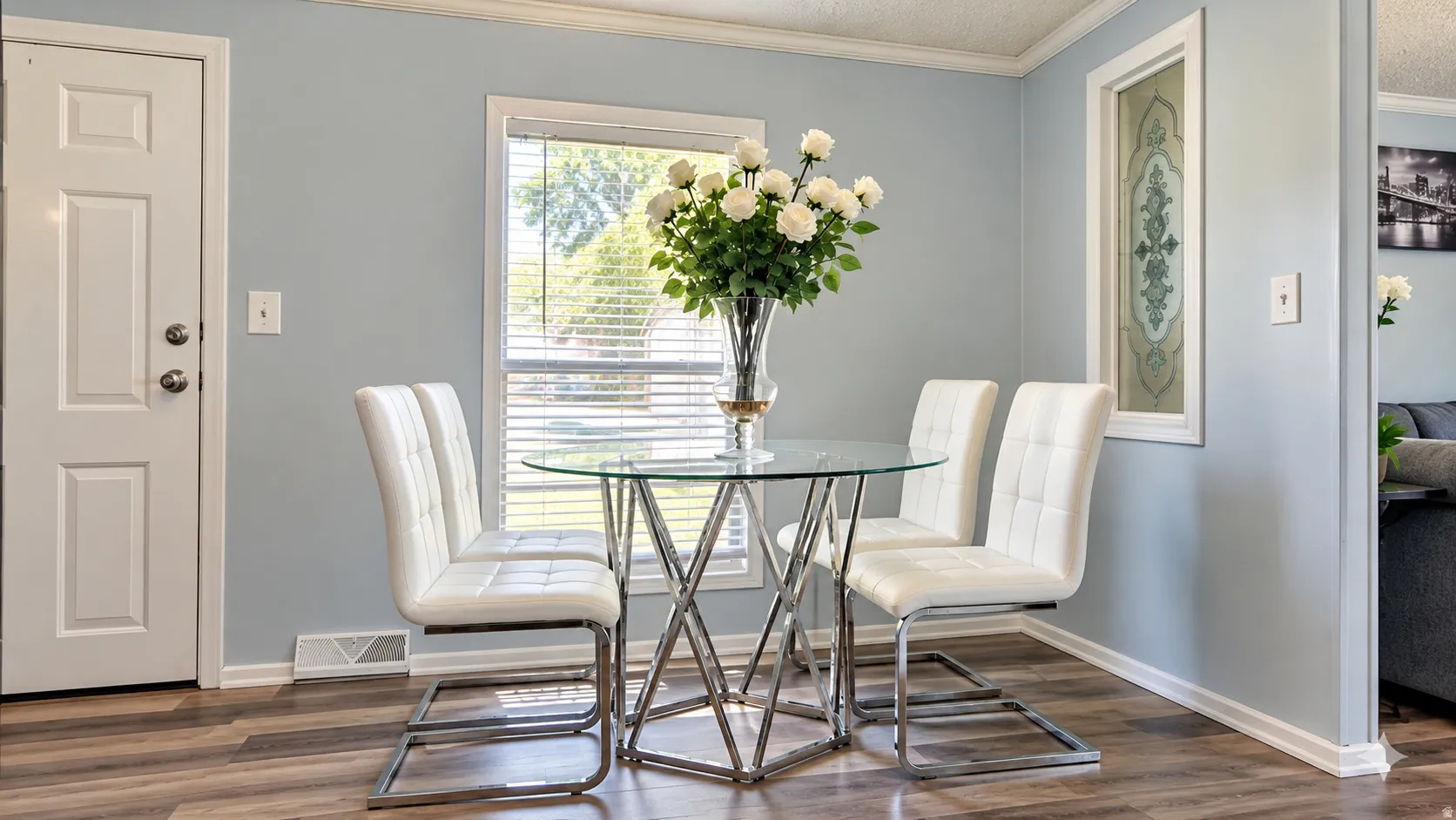Wood-finish flooring, light blue wall paint, white trim, and a window with blinds