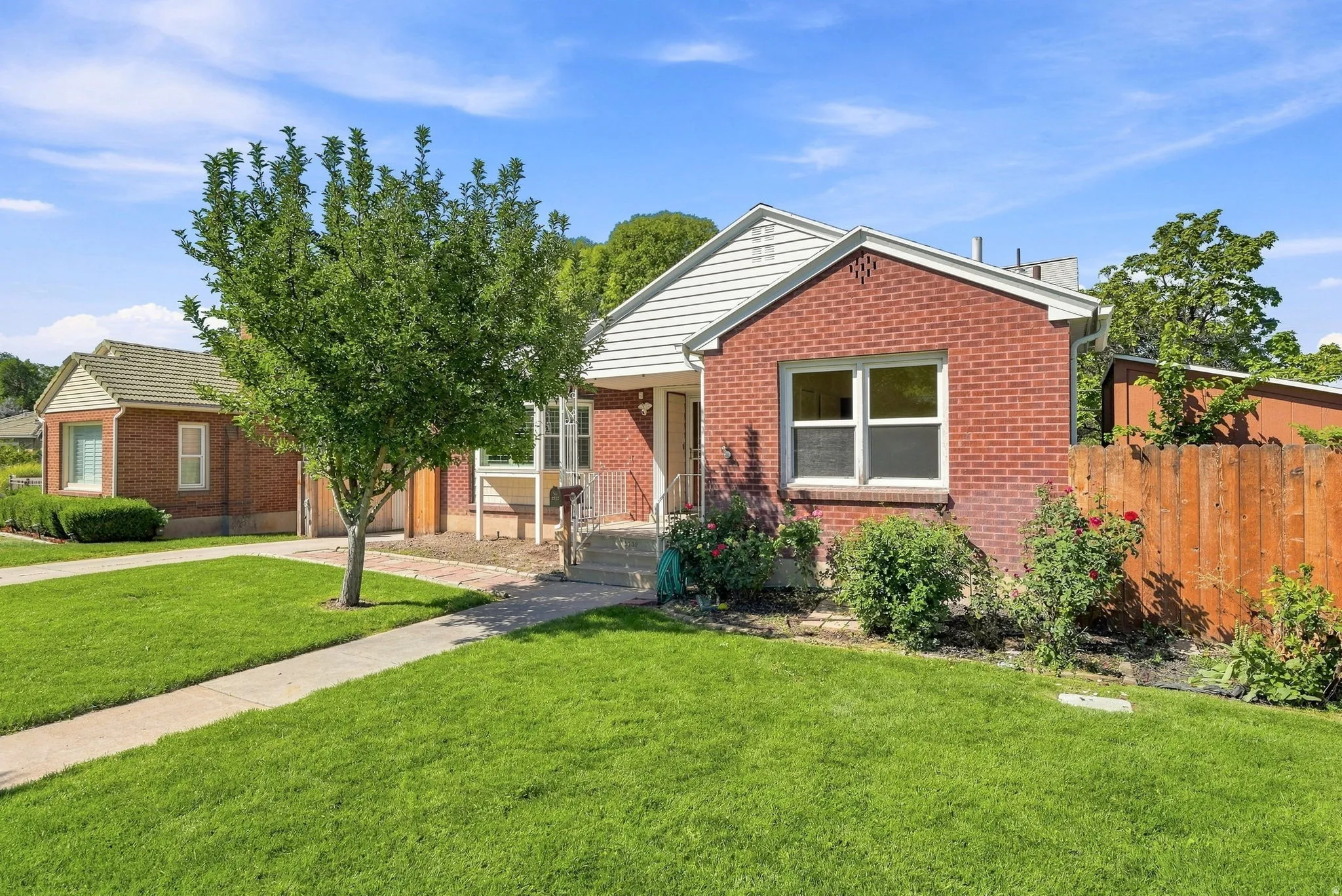 Brick exterior with white siding accents and a pitched roof