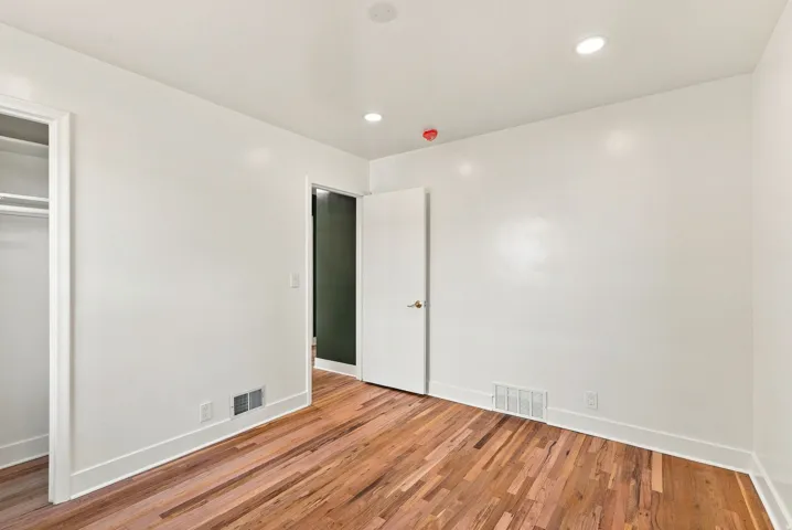 Hardwood flooring, recessed lighting, white walls, and white trim