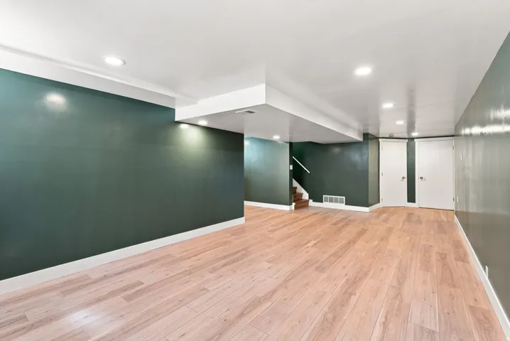 Recessed lighting, wood-finish flooring, and white trim
