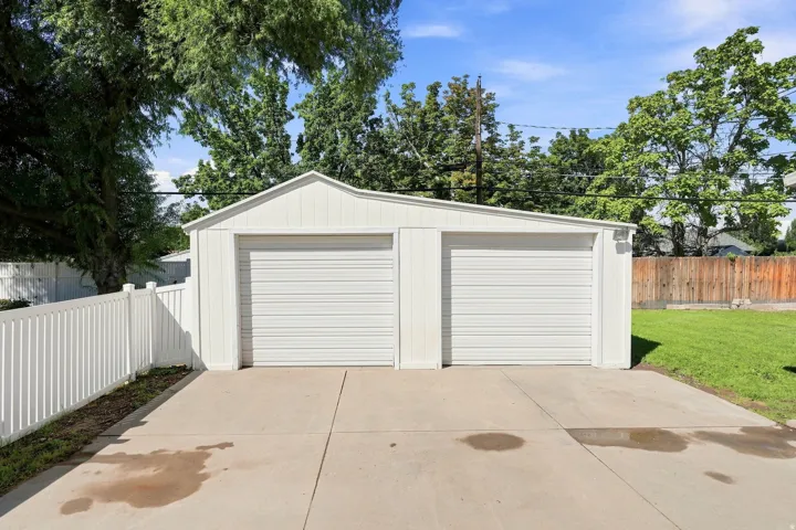 Two-car detached garage with white siding and a concrete driveway