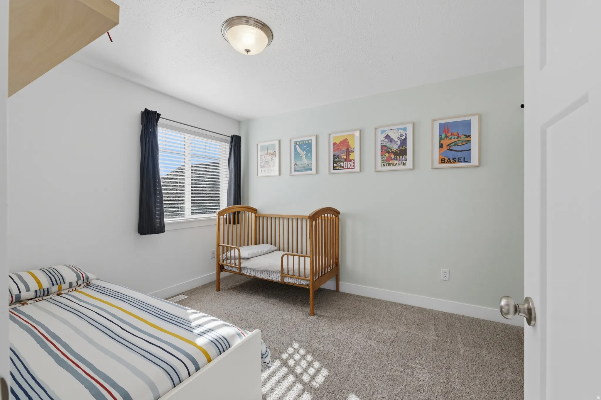 Recessed lighting fixture, light-toned wall paint, window with blinds, and neutral-toned carpeting