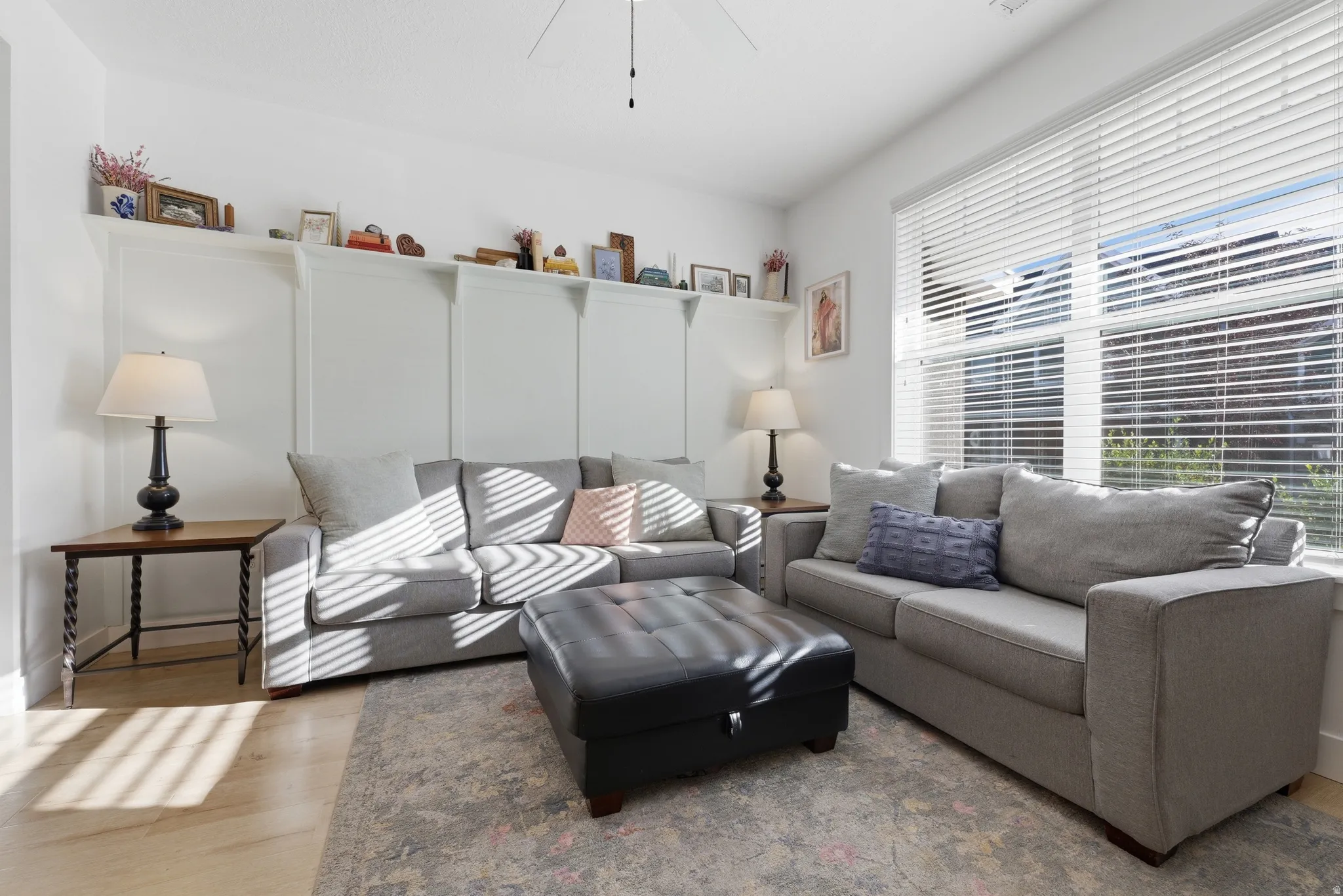 Expansive interior with light wood-finish flooring, built-in shelving, and large windows with blinds