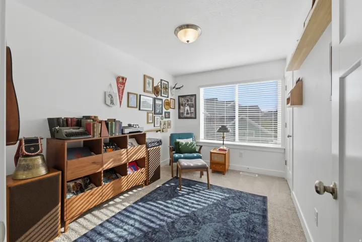 Recessed window with blinds, overhead flush mount lighting, light-toned carpet flooring, and a white wall finish