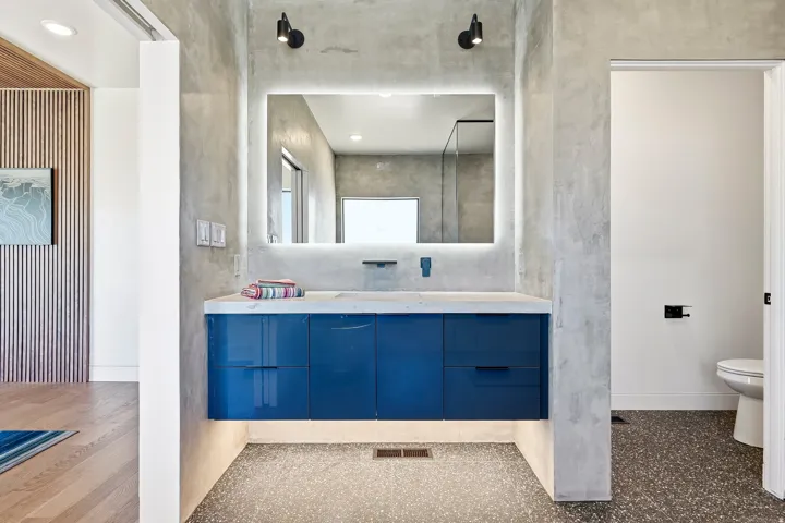 Floating vanity with a blue finish, integrated sink, and an illuminated mirror