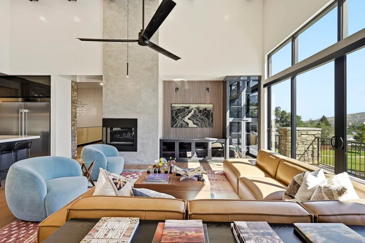 Vaulted ceilings, a full-height stone fireplace, and expansive glass sliding doors