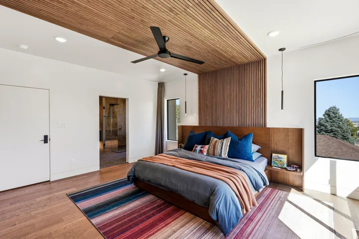 Hardwood flooring and a wood-slat accent wall with integrated wood headboard