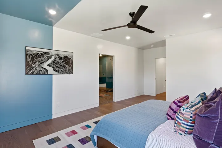 Wood-finish flooring with recessed lighting, a ceiling fan, and a partial accent wall