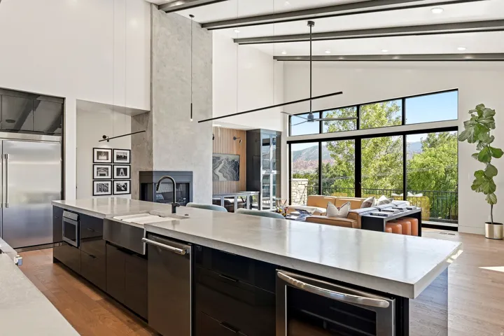 Gourmet kitchen island with integrated stainless steel appliances, farmhouse sink, and light-toned countertop