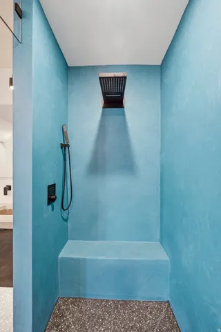 Walk-in shower with a built-in bench, integrated wall niche, and dark-finish fixtures