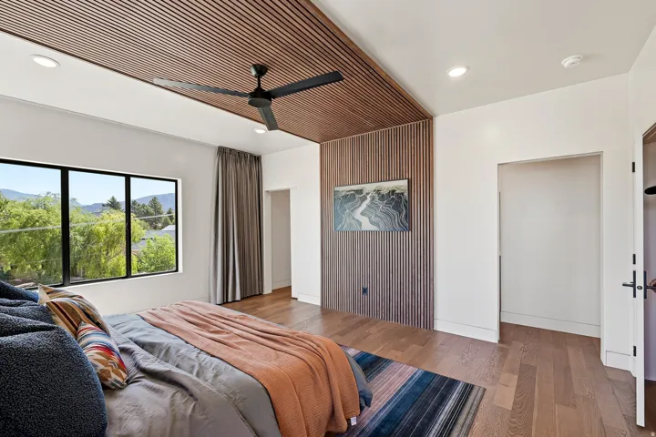 Wood-finish ceiling and wall accents, recessed lighting, and a modern ceiling fan