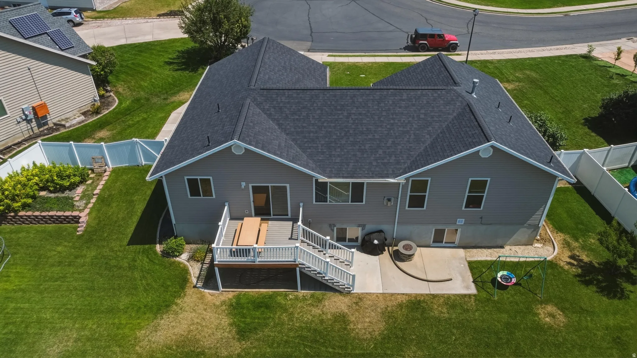 Expansive backyard featuring a multi-level deck, concrete patio, and mature landscaping