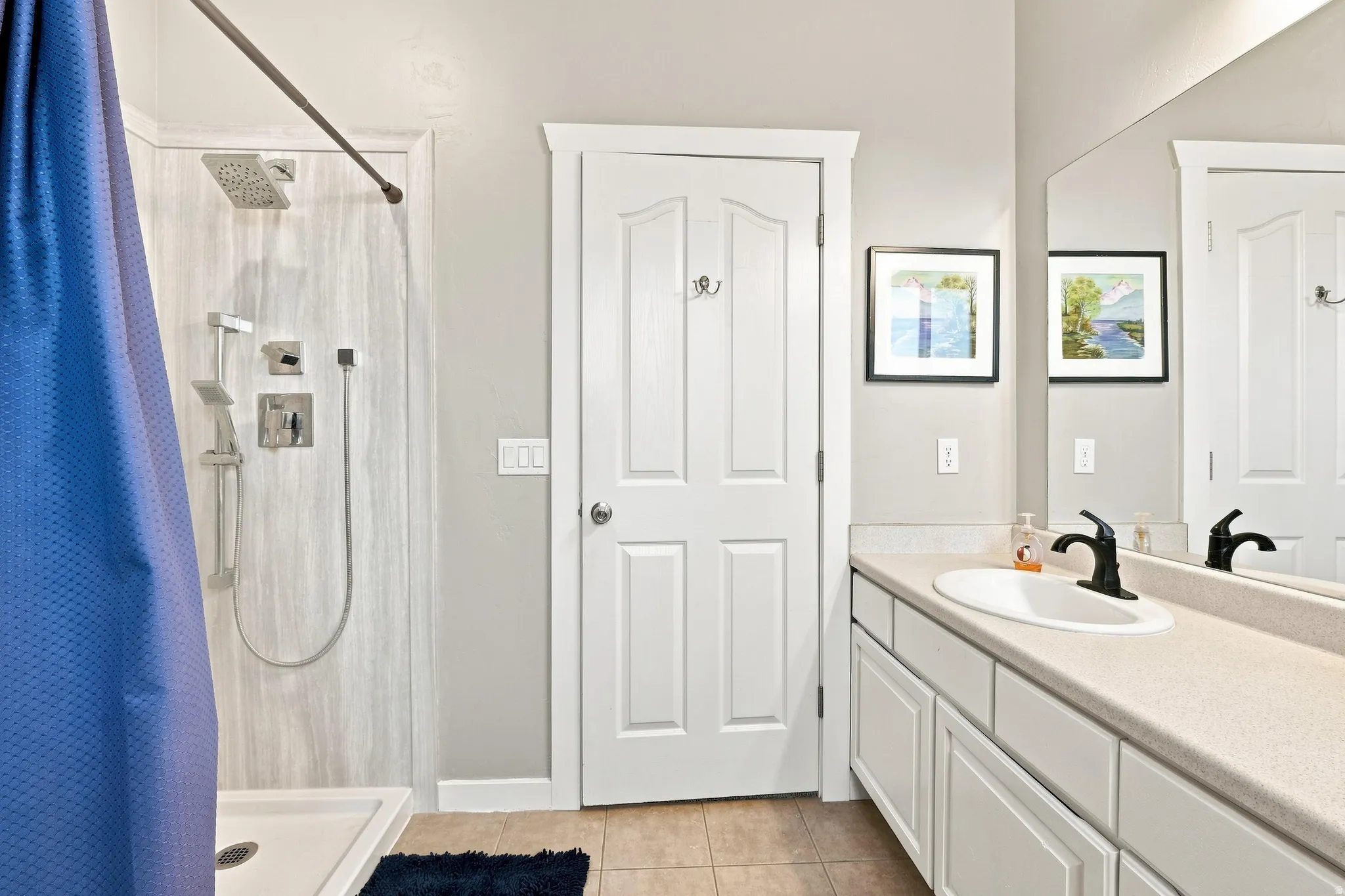 White paneled vanity with an integrated sink and black-finish faucet