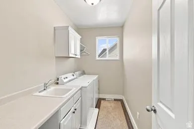 Laundry room with built-in cabinetry, utility sink, and ample countertop space