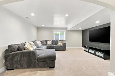 Recessed lighting, light-colored carpeting, and a window with blinds