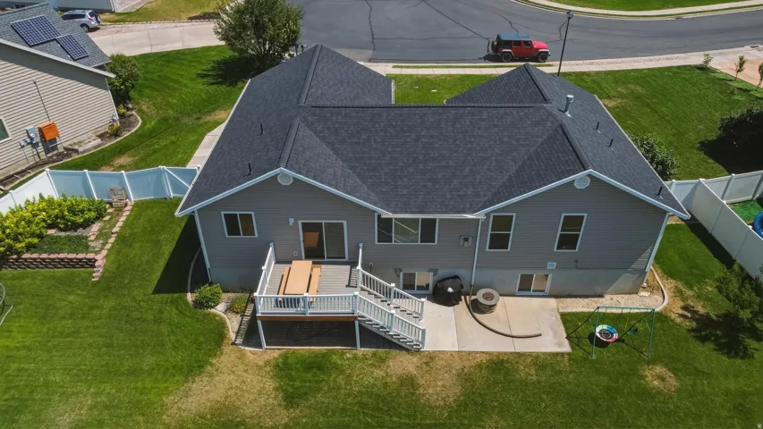 Expansive backyard featuring a multi-level deck, concrete patio, and mature landscaping