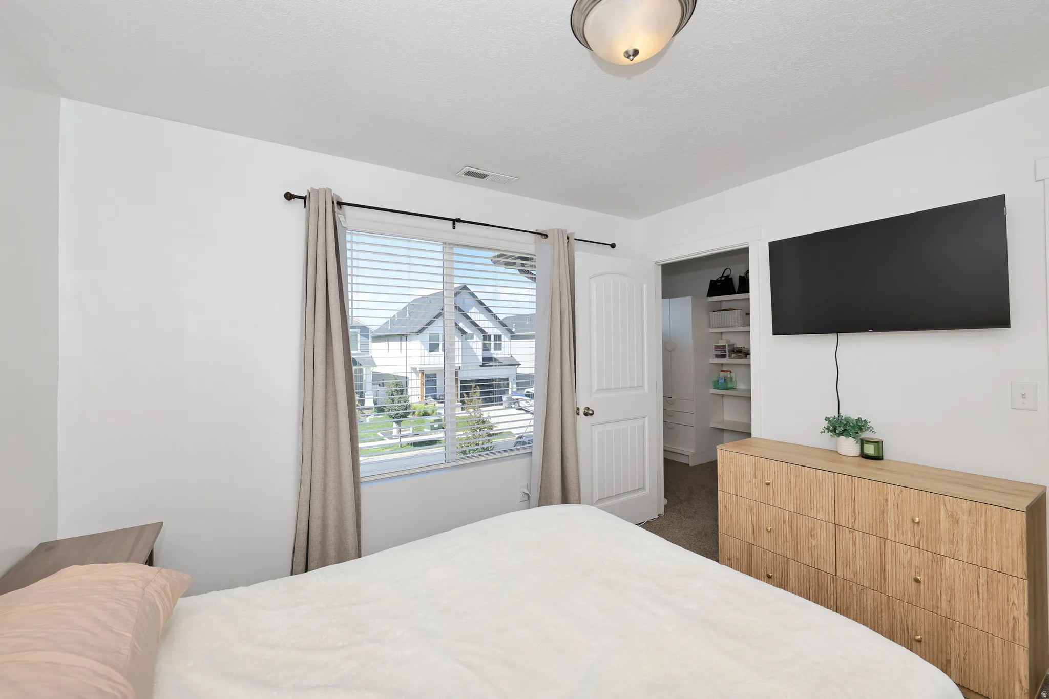 White interior walls with a window featuring horizontal blinds