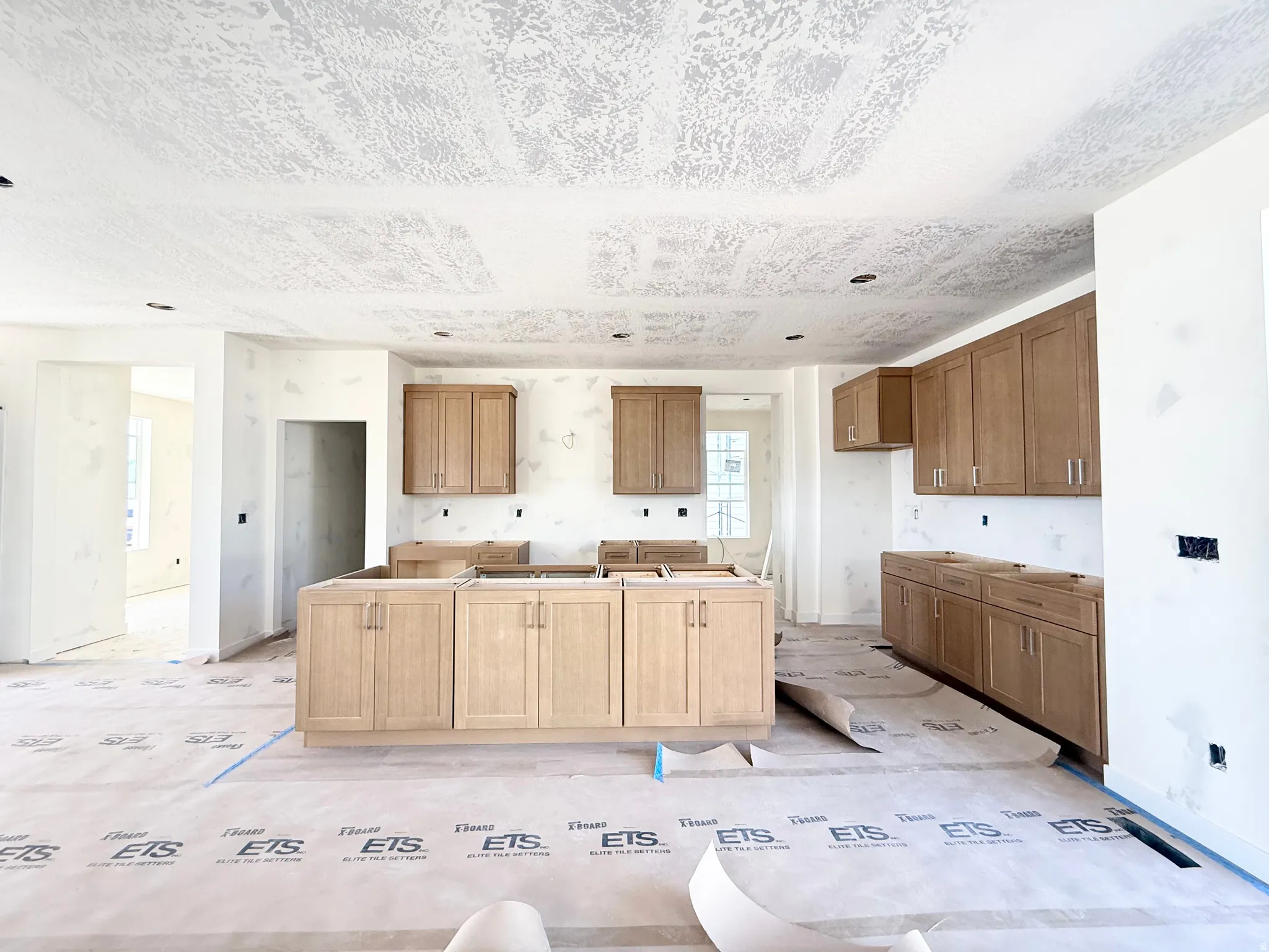 Kitchen space featuring a central island, light wood-finish cabinetry, and recessed lighting