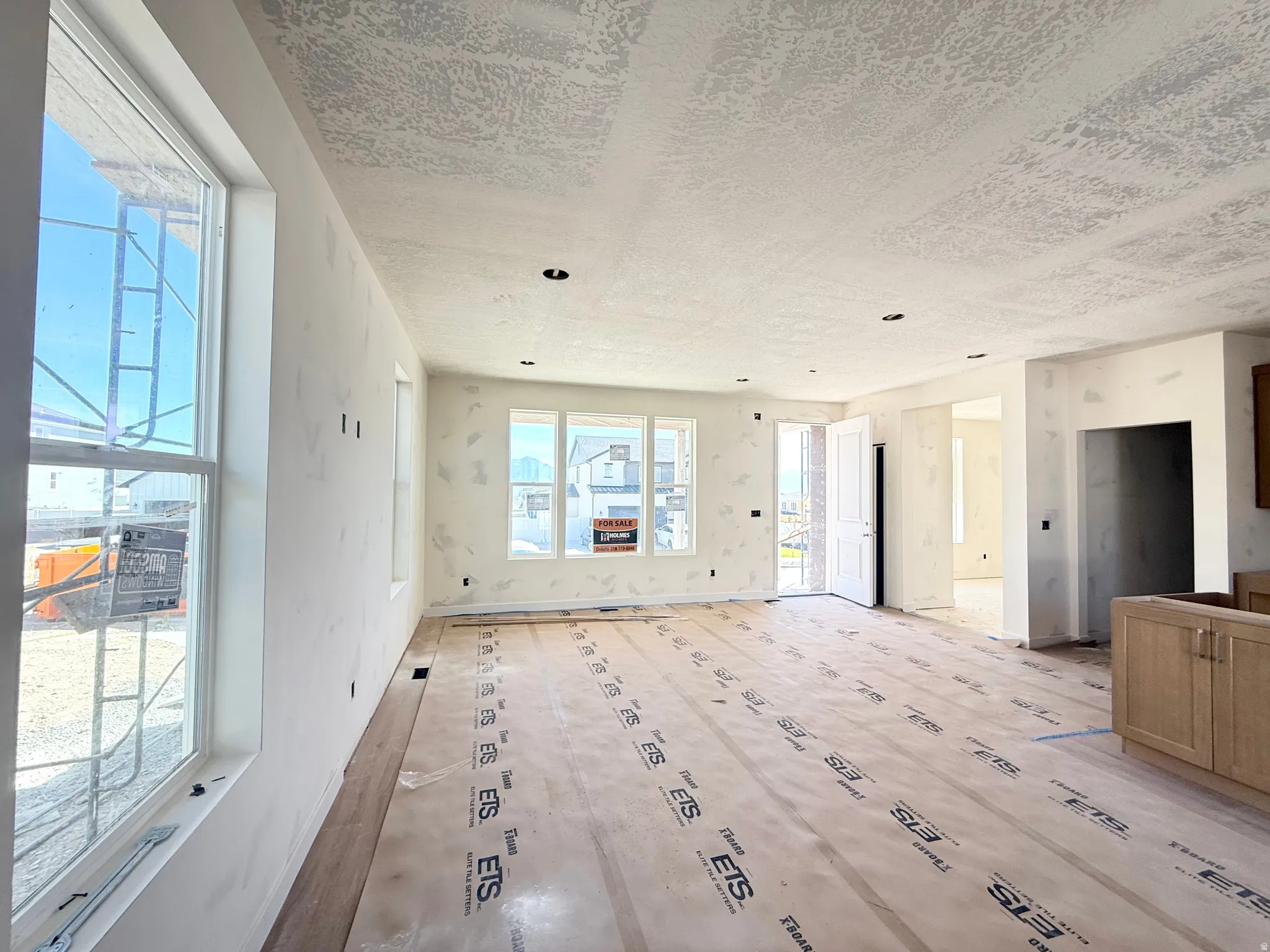 Recessed lighting and multiple windows illuminate the unfinished interior