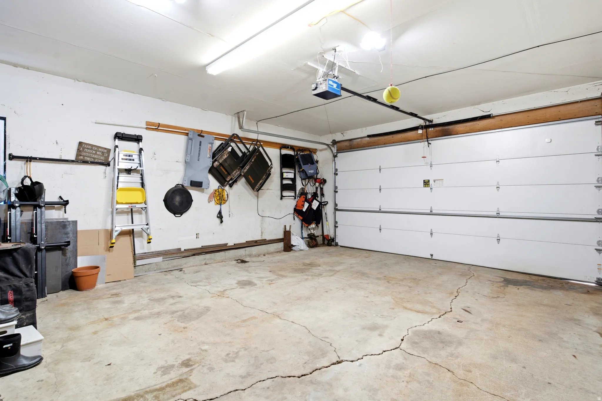 Garage space featuring a built-in overhead door, overhead lighting, and an automatic garage door opener