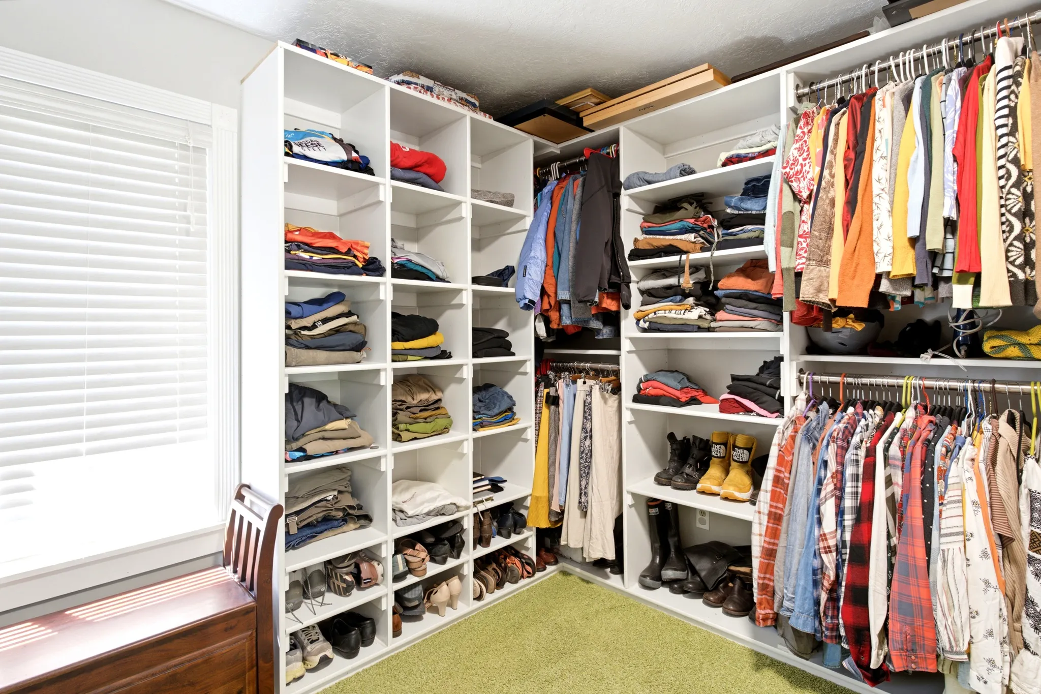 Custom closet organization system with extensive shelving and hanging rods