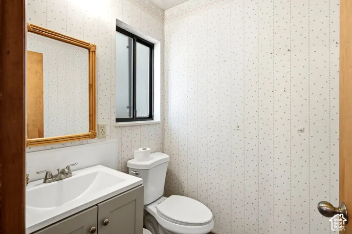 Powder room featuring a single vanity with a white sink, brushed nickel faucet, and a wall-mounted mirror
