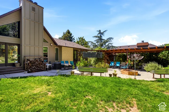 Expansive green lawn with a paver patio and a wood pergola