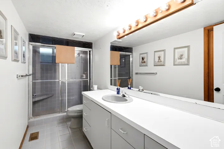 Full-width vanity with integrated sink, expansive mirror, and overhead lighting