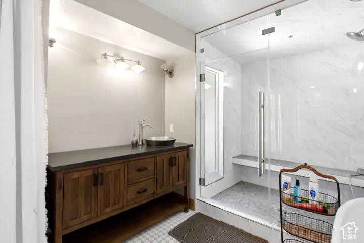 Glass-enclosed shower with a built-in bench, marble-finish wall tile, and a rainfall showerhead