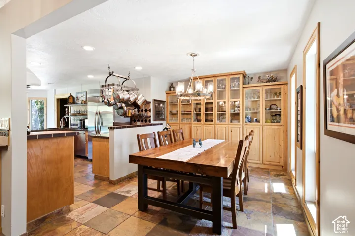 Open-concept dining area featuring tiled flooring, built-in display cabinetry, and a chandelier