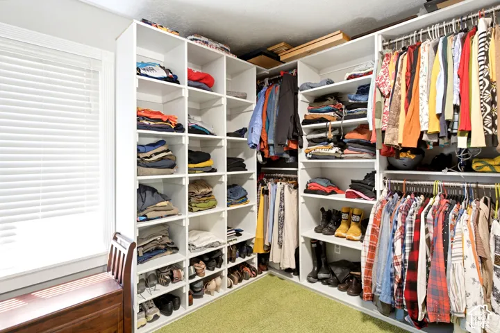 Custom closet organization system with extensive shelving and hanging rods