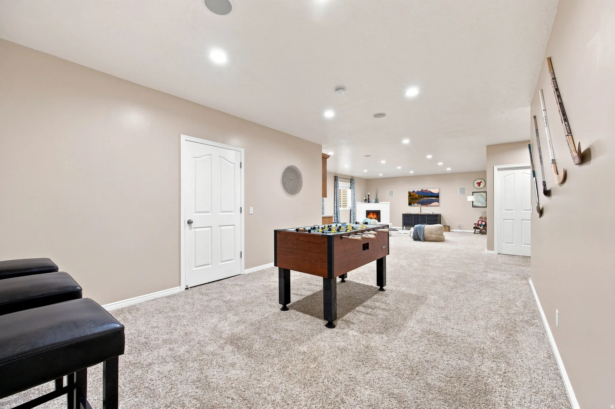 Recessed lighting, light-toned walls, and carpet flooring create an inviting atmosphere