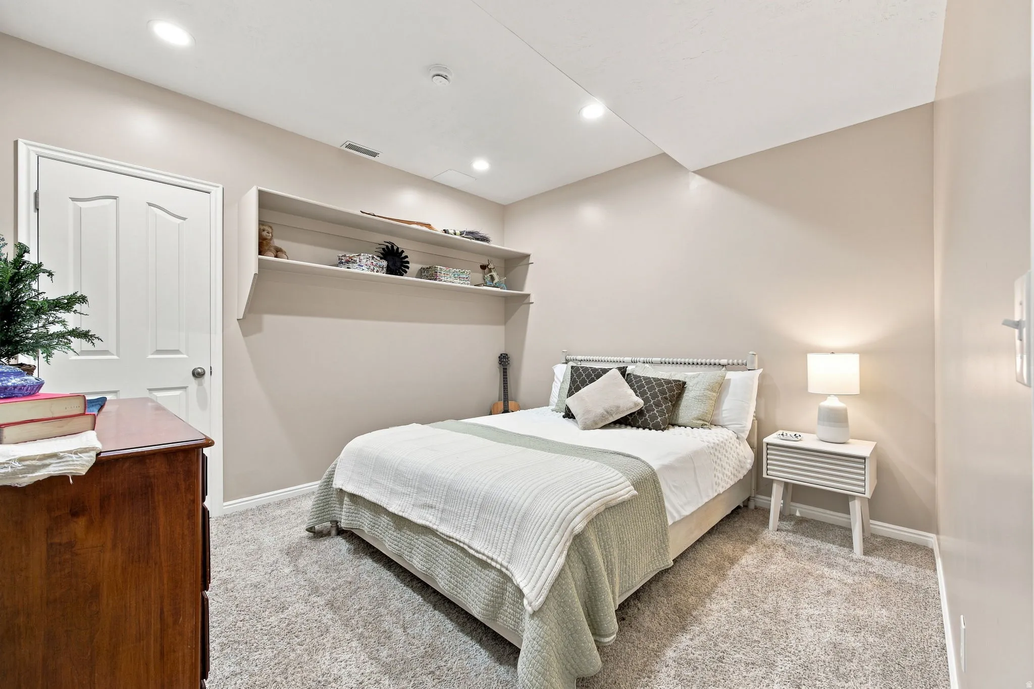 Recessed lighting, light-toned walls, and soft gray carpet
