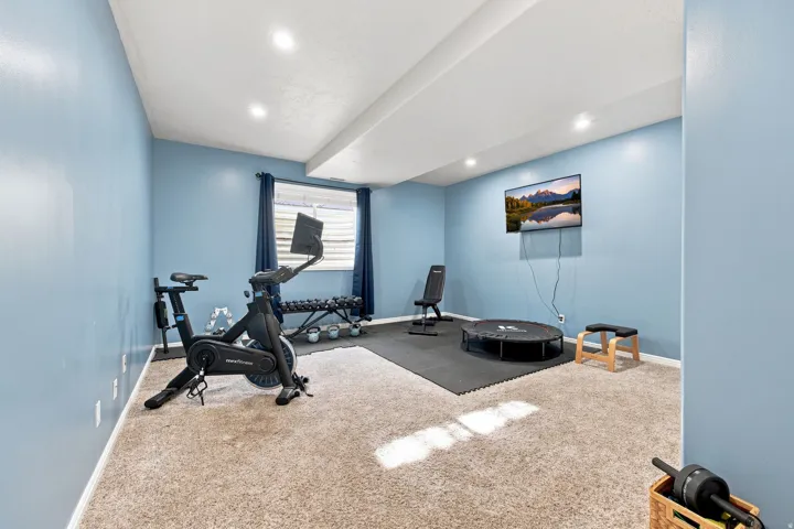 Carpeted room with recessed lighting and a window with blinds