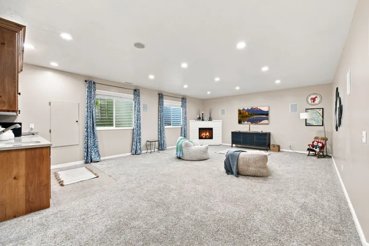Spacious room featuring light-colored carpeting, recessed lighting, and built-in cabinetry with a light-toned countertop