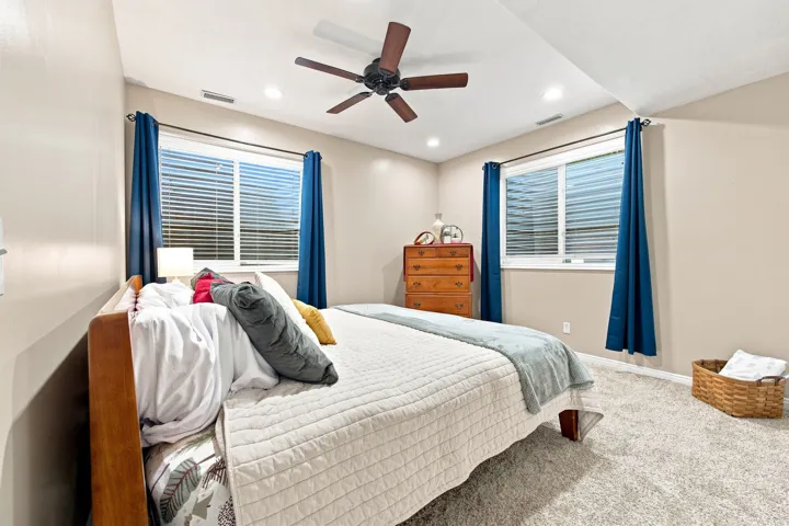 Recessed lighting, wood-finish ceiling fan, and light-colored carpeting