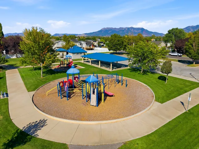 Expansive park area featuring a playground, walking paths, and a covered pavilion