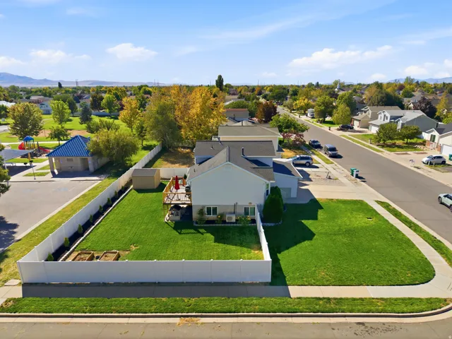Expansive lot featuring a large lawn, white privacy fencing, and an elevated wood deck