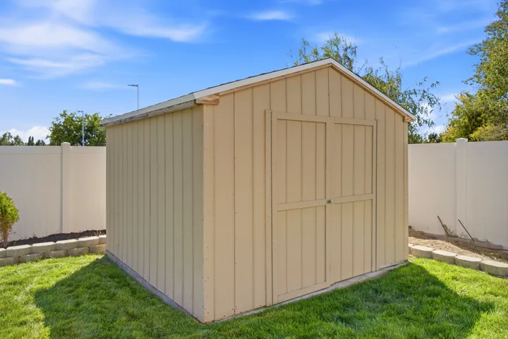 Freestanding outdoor shed with wood panel siding, double-door entry, and a pitched roof
