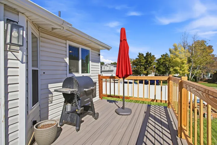 Outdoor deck featuring composite flooring, wood railings, and a vinyl-sided exterior